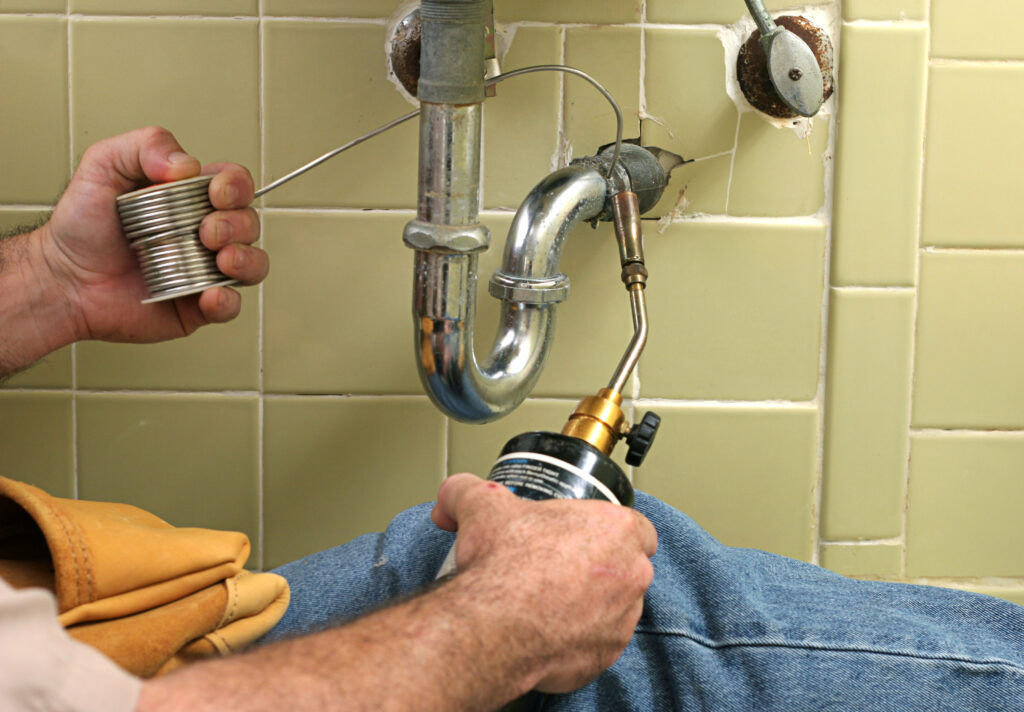 Commercial plumber fixing a sink drain about us