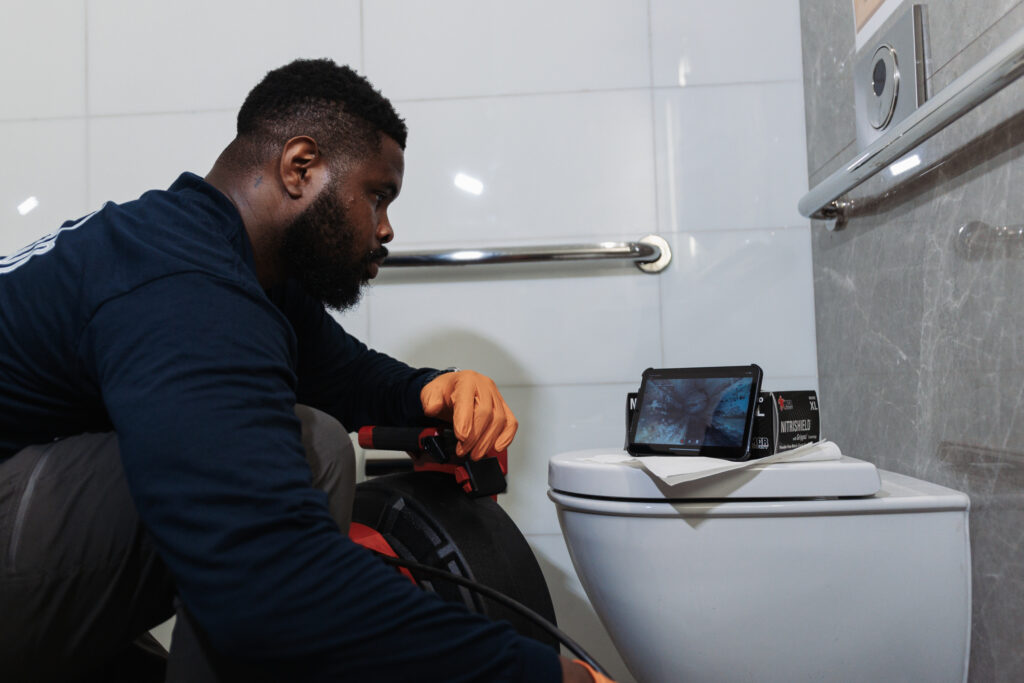 Miami plumber inspecting a clogged drain with a camera